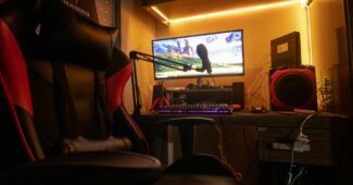 Patogi žaidimų kėdė su reguliuojamais porankiais ir nugaros atrama moderniame kambaryje.